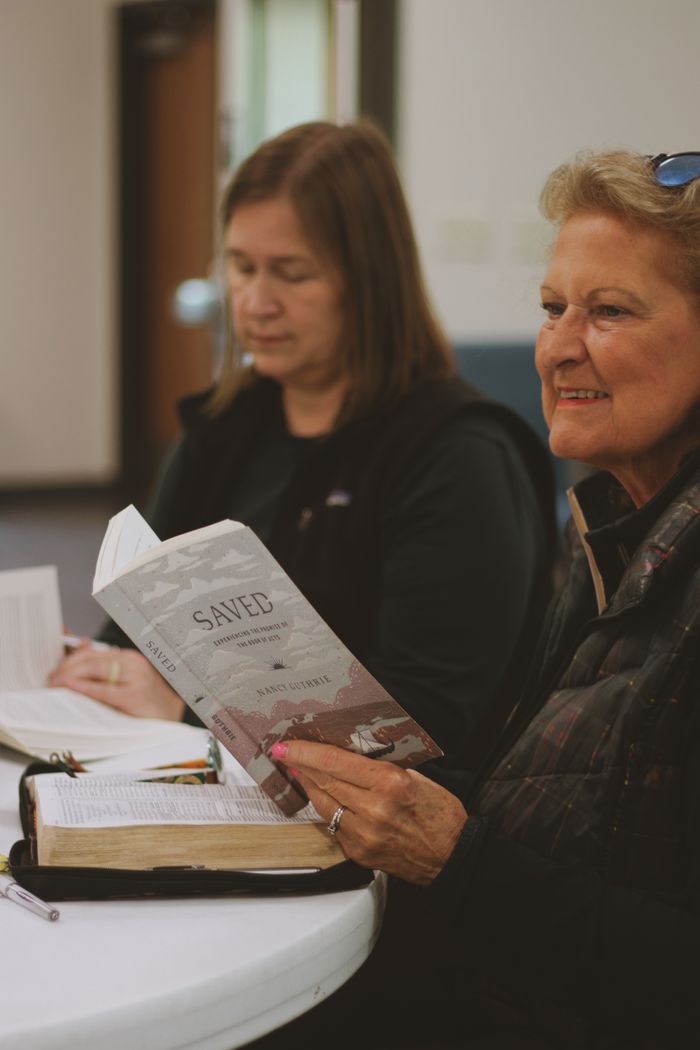 Crafting Captivating Headlines: Your awesome post title goes here Women gathered around a table studying the Bible and religious texts in fellowship.
