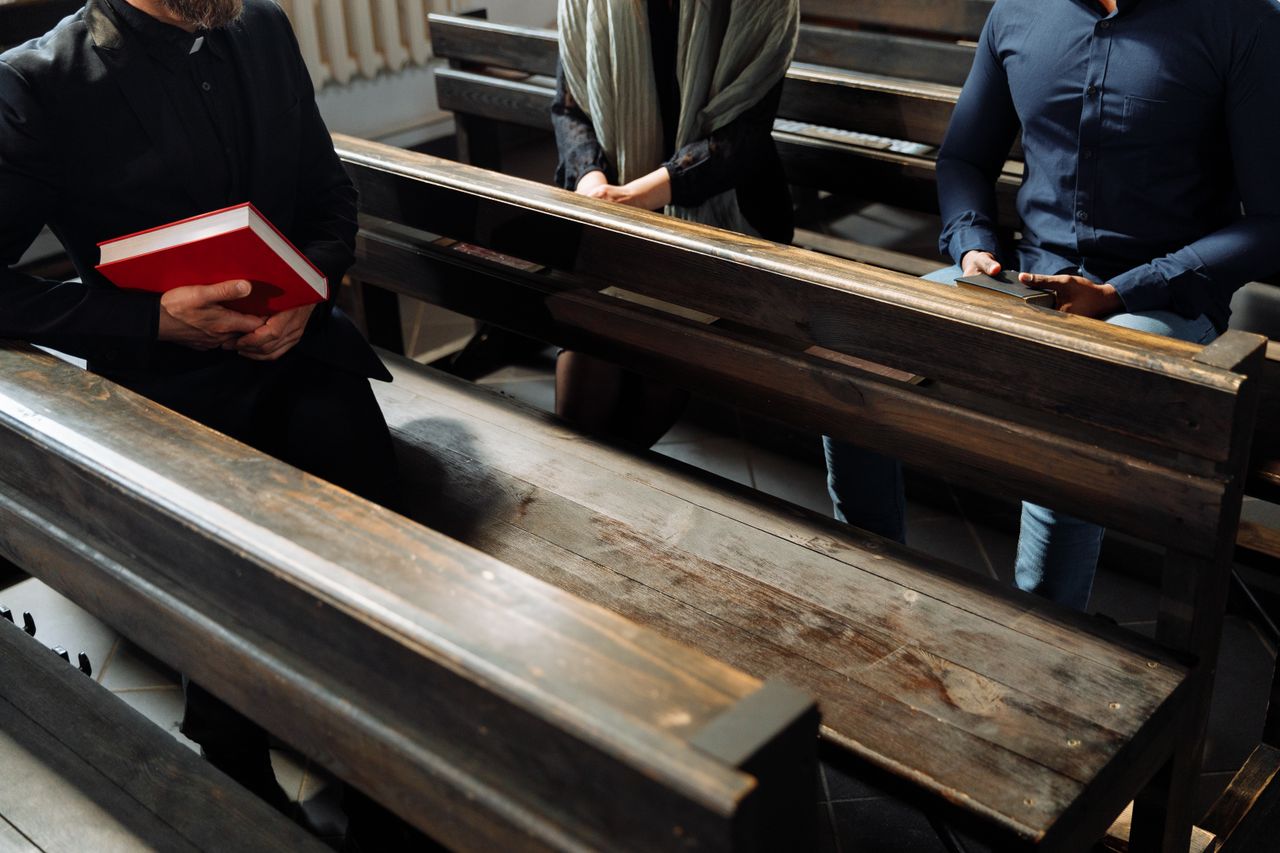 why-choose-us People sitting on wooden benches inside a church with a focus on religious gatherings.